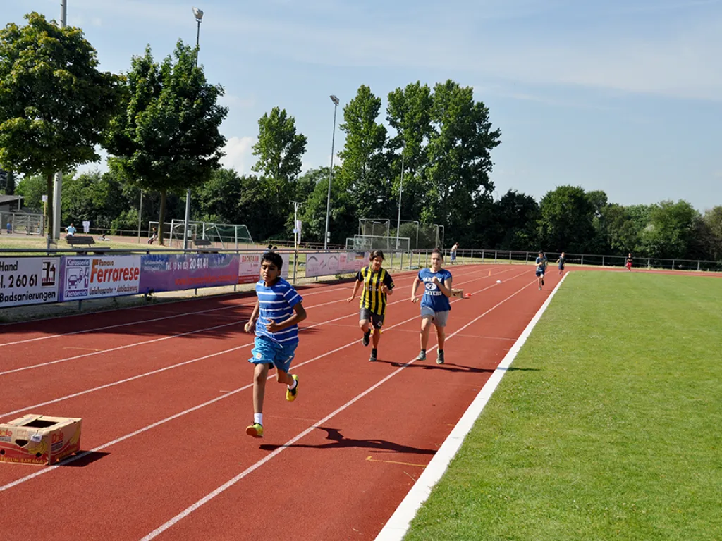 Drei Läufer sprinten nebeneinander.